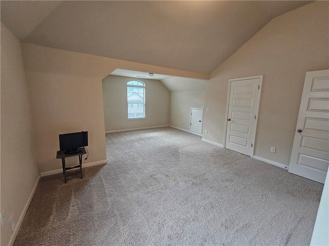 bonus room featuring lofted ceiling, carpet flooring, and baseboards