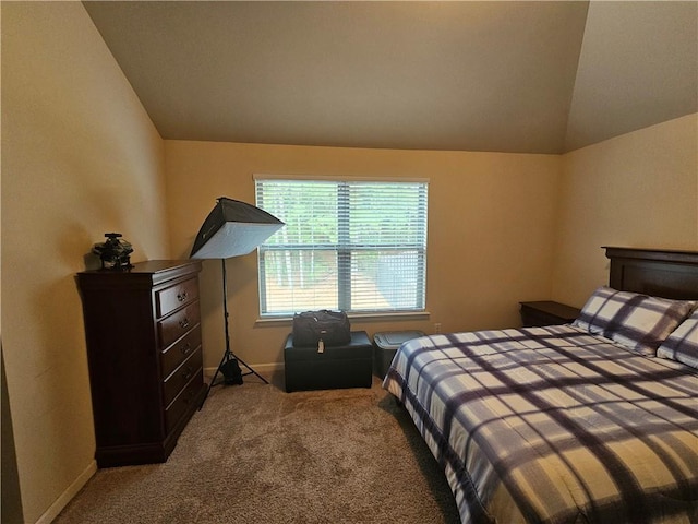 carpeted bedroom featuring vaulted ceiling and baseboards