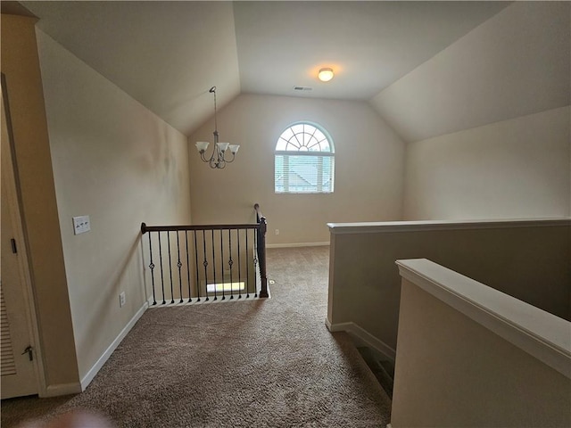 hallway featuring an upstairs landing, carpet, vaulted ceiling, baseboards, and a chandelier