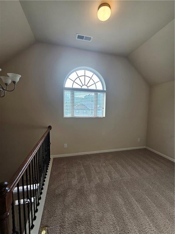 additional living space featuring vaulted ceiling, carpet, baseboards, and a chandelier
