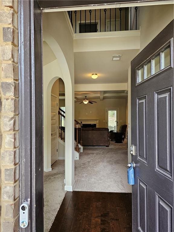 1750 Stone Meadow Rd, Lithonia, GA 30058 - entrance foyer featuring arched walkways, ceiling fan, dark wood-style floors, a towering ceiling, and dark colored carpet