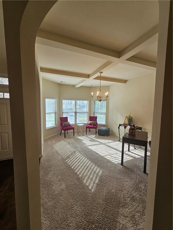 interior space with carpet flooring, arched walkways, beamed ceiling, baseboards, and a chandelier