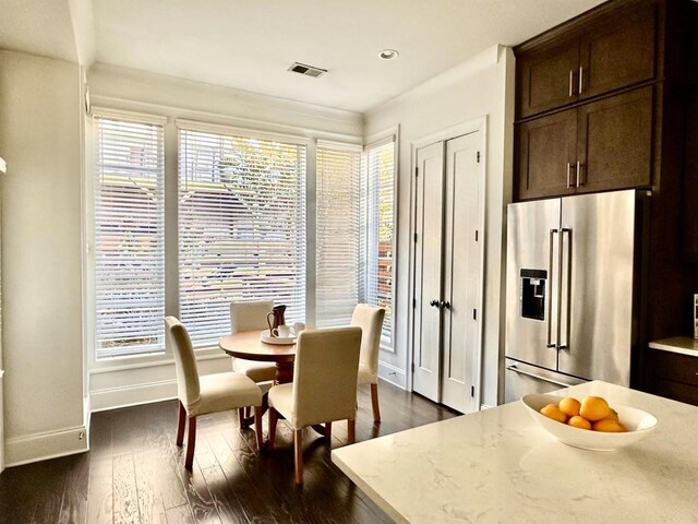 dining room featuring dark hardwood / wood-style flooring and a healthy amount of sunlight