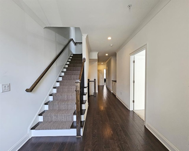 stairs with hardwood / wood-style flooring and crown molding