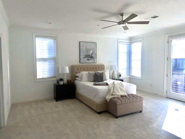 carpeted bedroom with multiple windows, ceiling fan, and access to exterior