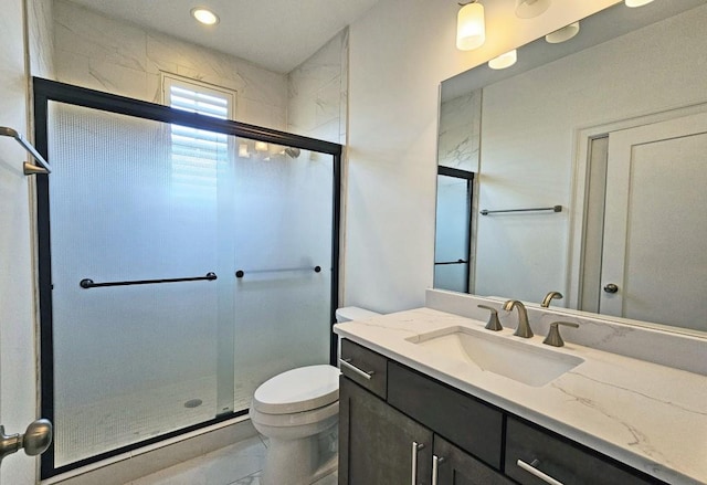 bathroom with vanity, an enclosed shower, and toilet