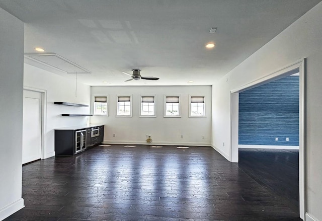 unfurnished living room with dark hardwood / wood-style floors and ceiling fan