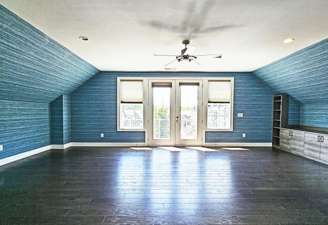 additional living space featuring a textured ceiling, dark hardwood / wood-style flooring, and lofted ceiling