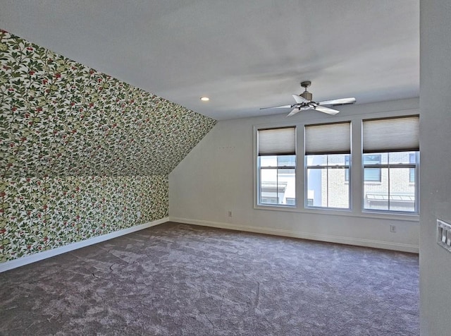 bonus room featuring a healthy amount of sunlight, dark carpet, and lofted ceiling