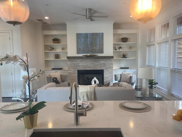 living room featuring ceiling fan and built in features