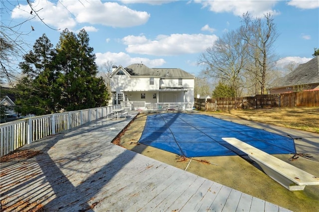 view of swimming pool with a diving board and a wooden deck