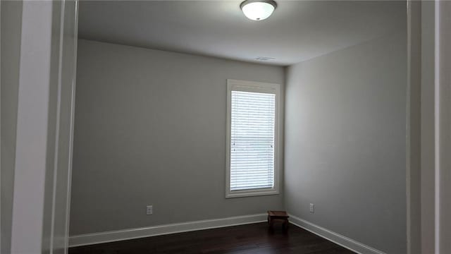 unfurnished room with plenty of natural light, dark wood-style floors, and baseboards