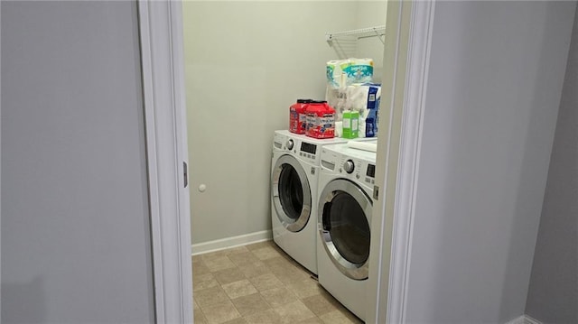 laundry area featuring washing machine and clothes dryer and baseboards