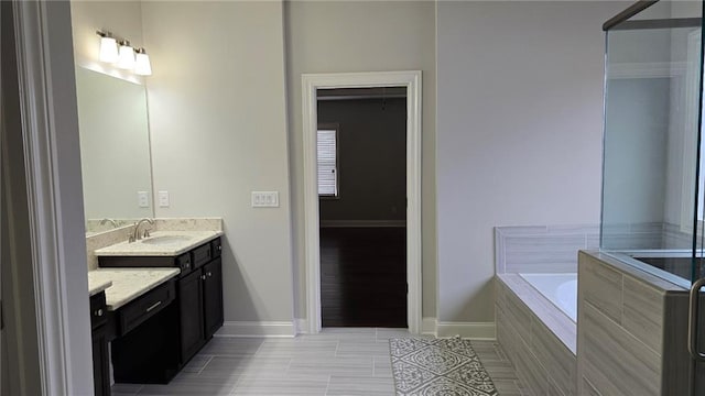 bathroom featuring a garden tub, baseboards, vanity, and tile patterned floors