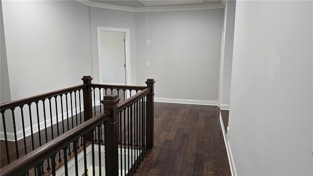 corridor featuring an upstairs landing, dark wood finished floors, attic access, baseboards, and ornamental molding