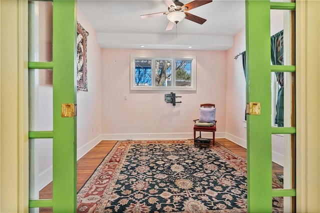 interior space featuring ceiling fan, wood finished floors, and baseboards