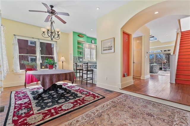 interior space with arched walkways, recessed lighting, visible vents, wood finished floors, and baseboards