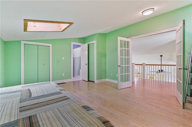 unfurnished bedroom featuring french doors, wood finished floors, and baseboards