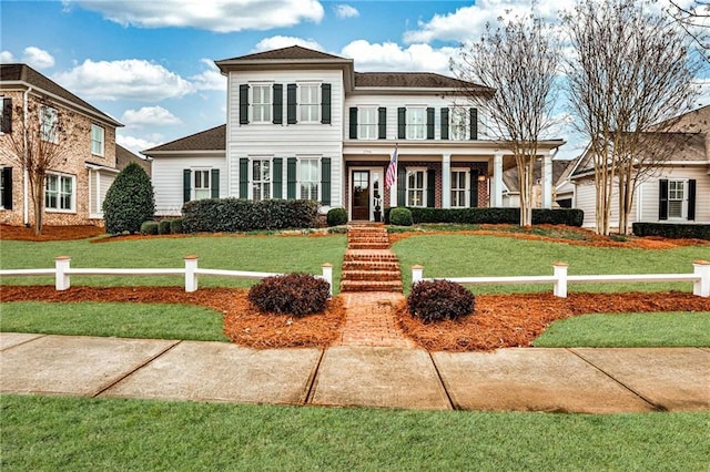 view of front facade featuring a balcony and a front lawn