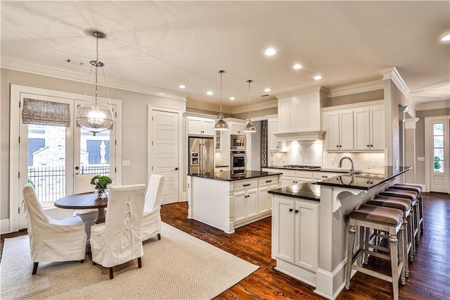 kitchen featuring a kitchen island, dark wood finished floors, decorative backsplash, appliances with stainless steel finishes, and dark countertops