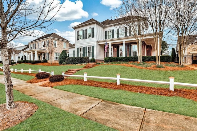 view of front facade featuring a front yard and fence