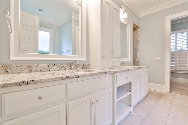 full bath featuring crown molding, double vanity, baseboards, and a sink