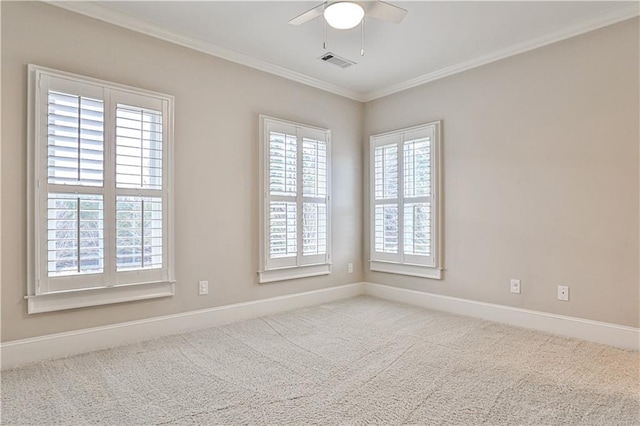 spare room featuring visible vents, baseboards, ceiling fan, crown molding, and carpet flooring