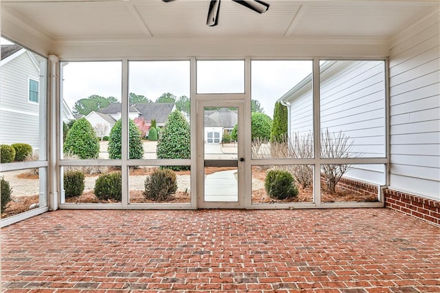 unfurnished sunroom with ceiling fan