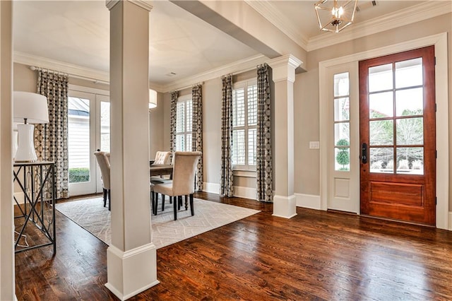 entryway with crown molding, decorative columns, and wood finished floors