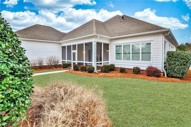 exterior space with a sunroom, a front lawn, and roof with shingles