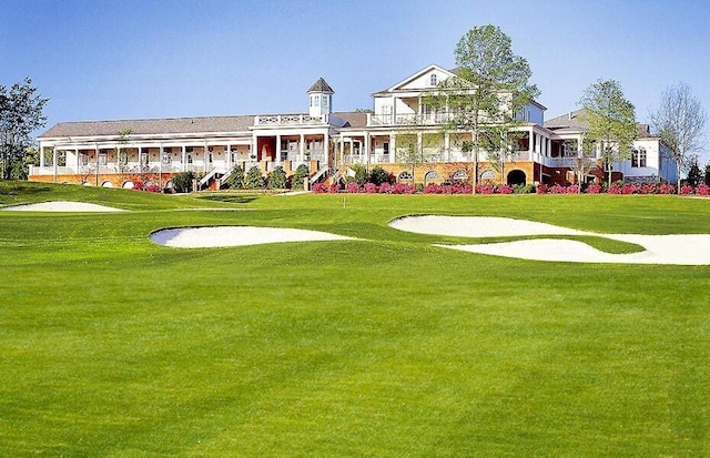 surrounding community featuring a yard and golf course view
