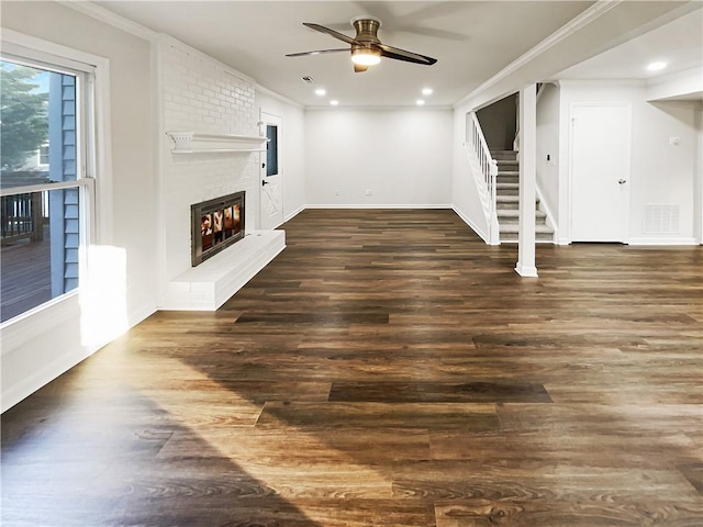 unfurnished living room featuring crown molding, visible vents, a fireplace, and stairway