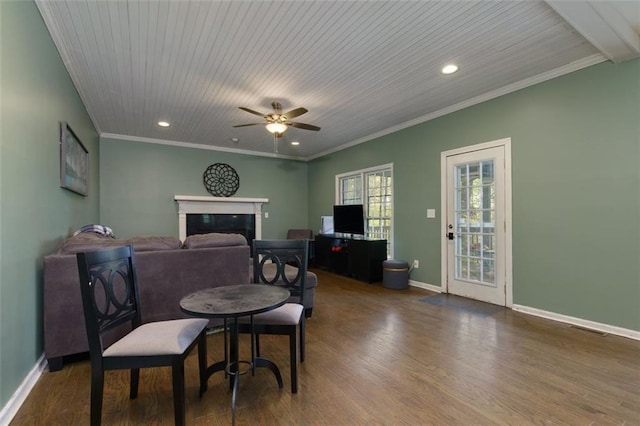 dining area featuring baseboards, wood finished floors, a glass covered fireplace, and ceiling fan