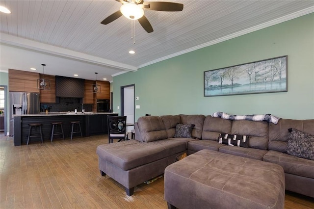 living room featuring recessed lighting, light wood-type flooring, beam ceiling, and a ceiling fan