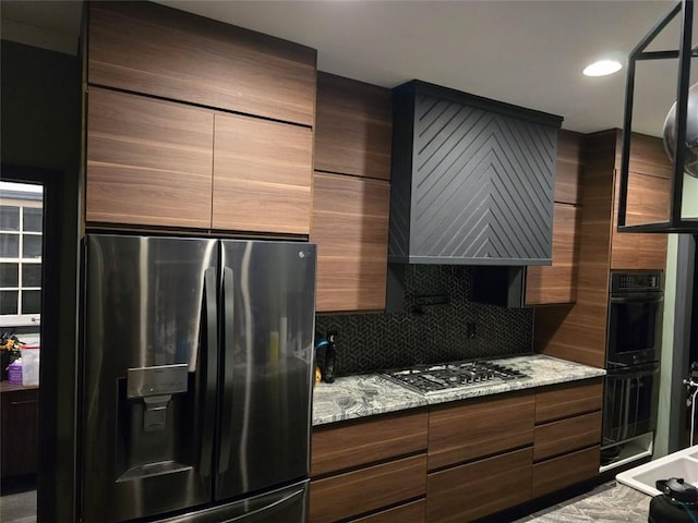 kitchen featuring stainless steel gas stovetop, modern cabinets, and refrigerator with ice dispenser