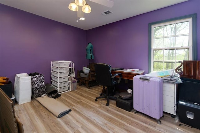 office space featuring wood finished floors, visible vents, and a ceiling fan
