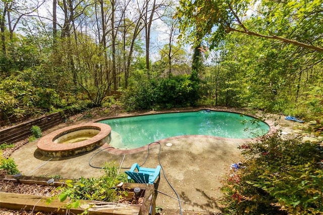 view of swimming pool featuring a patio and a pool with connected hot tub