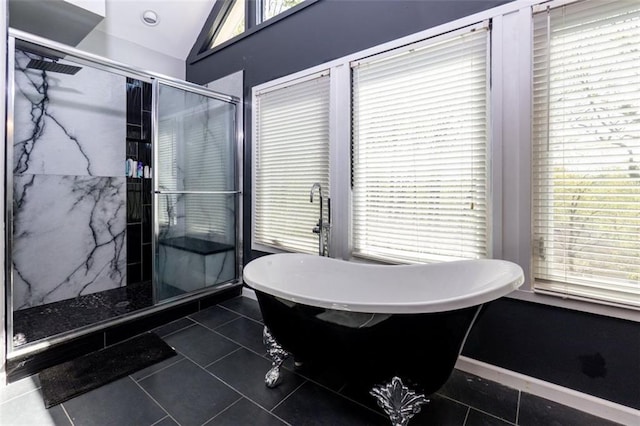 bathroom with vaulted ceiling, a marble finish shower, tile patterned flooring, and a freestanding bath