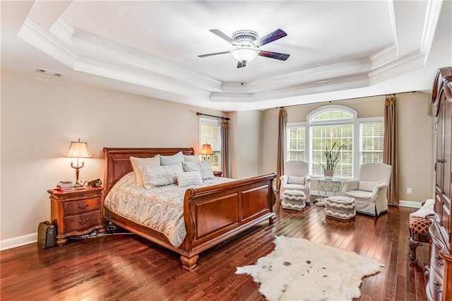 bedroom featuring crown molding, dark hardwood / wood-style floors, a tray ceiling, and ceiling fan