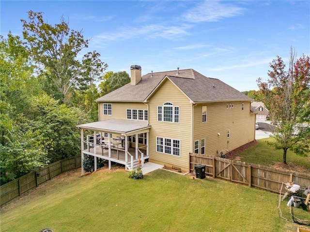 back of house with a deck and a yard