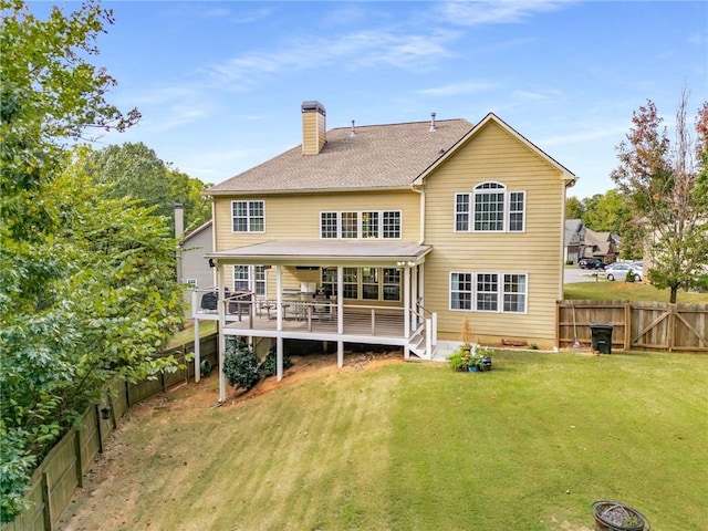 back of house featuring a yard and a wooden deck