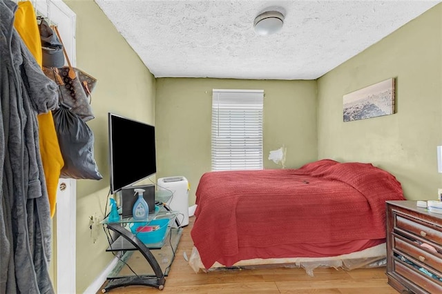 bedroom featuring light hardwood / wood-style flooring and a textured ceiling