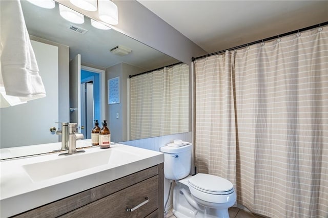 bathroom featuring vanity, tile patterned flooring, and toilet