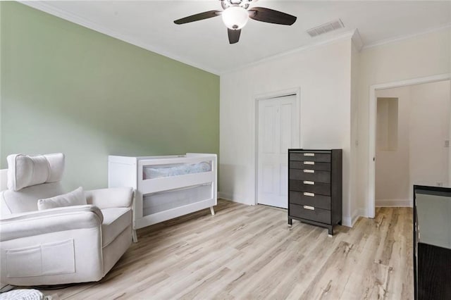 sitting room featuring crown molding, light wood-type flooring, and a ceiling fan