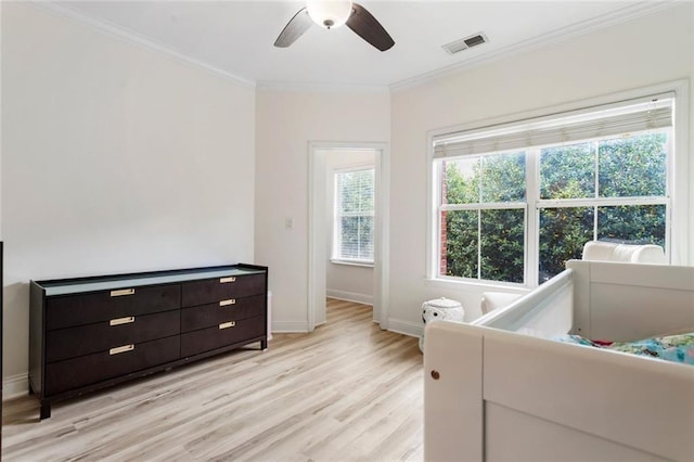 bedroom featuring light wood finished floors, ornamental molding, and a ceiling fan