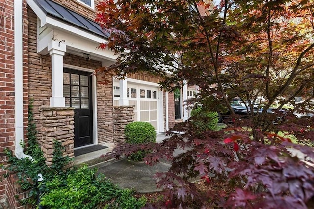 doorway to property featuring stone siding, brick siding, a standing seam roof, and a metal roof