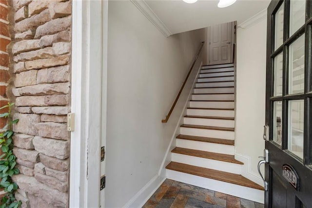 staircase with stone tile flooring and ornamental molding