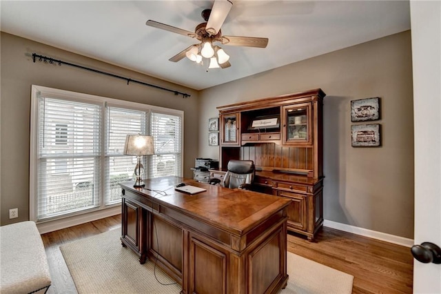 office with light wood finished floors, baseboards, and a ceiling fan