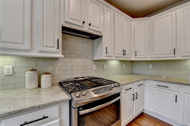 kitchen with light stone counters, stainless steel range with gas cooktop, white cabinetry, and decorative backsplash