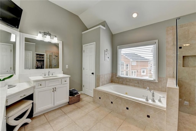 bathroom featuring a closet, tile patterned flooring, a tile shower, vaulted ceiling, and a bath